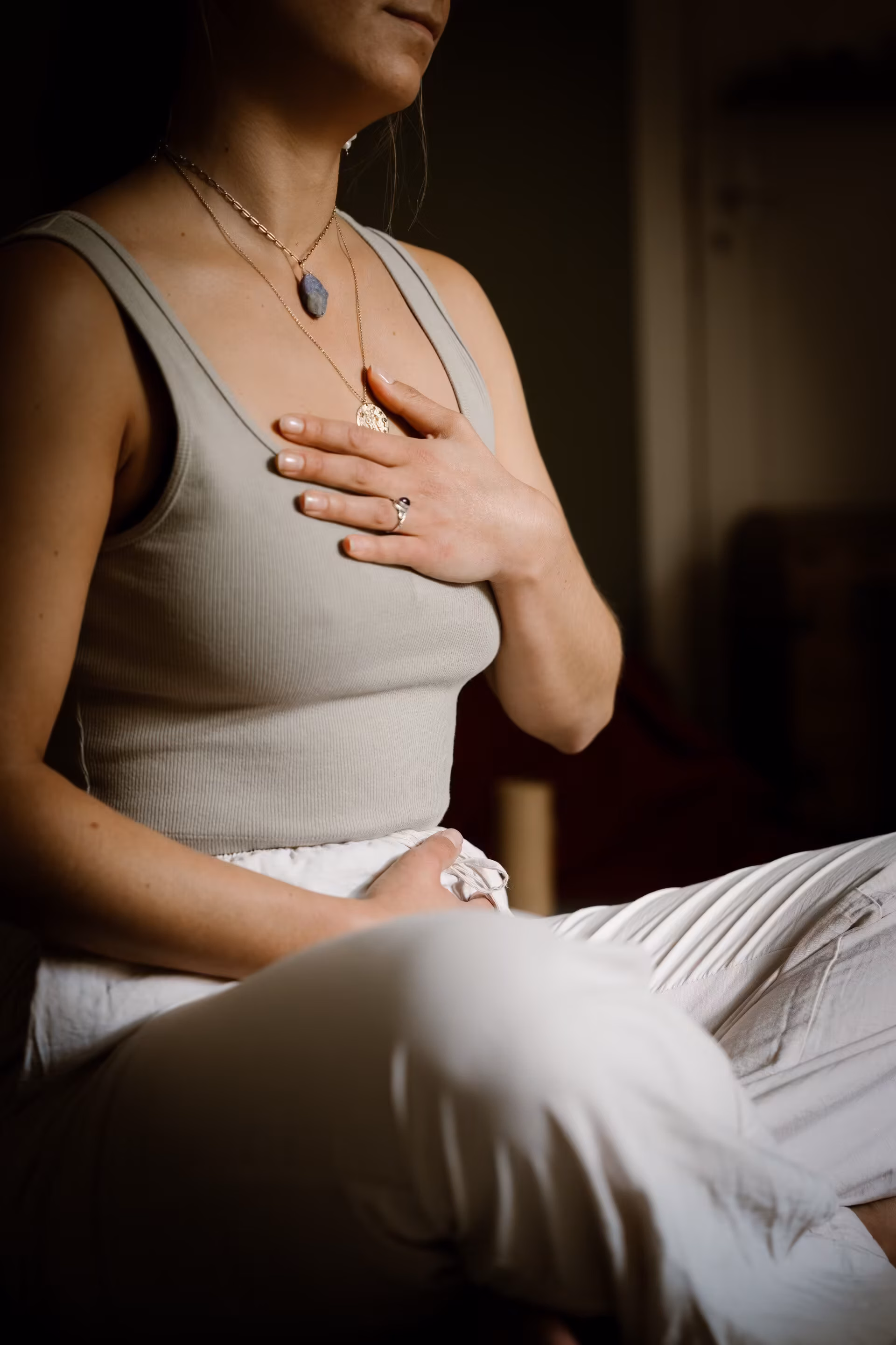 Vrouw met haar hand op haar hart tijdens een ademsessie